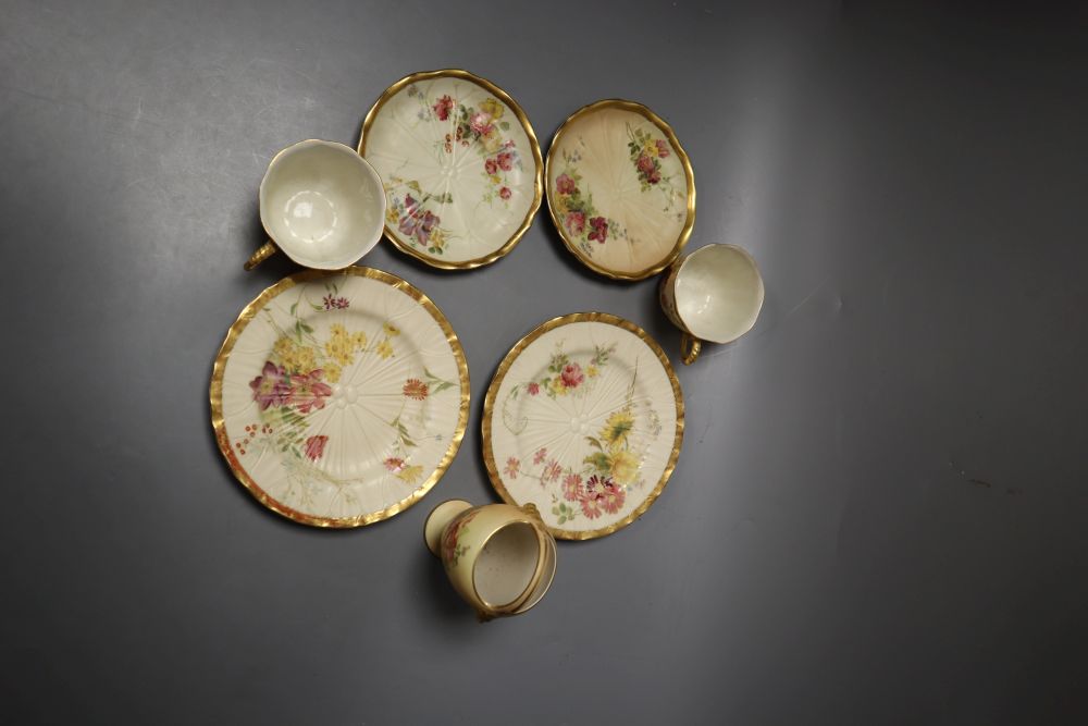 A Royal Worcester over-handled vase painted with flower on a blush ivory ground and two Royal Worcester cups, saucers and side plates